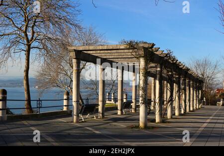 Una pergola in pietra e cemento accanto alla baia di Santander Cantabria Spagna su una soleggiata mattina invernale alta Reina Victoria vista strada Foto Stock