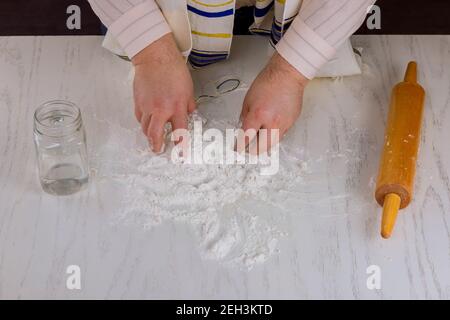 L'uomo ebreo ortodosso si prepara per la festa ebraica kosher matzah fatto a mano preparare Foto Stock