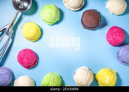 Coloratissimi cucchiai di gelato su sfondo blu pastello. Summer minimalism motivo piatto con luce dura. Mirtillo alla vaniglia al cioccolato Foto Stock