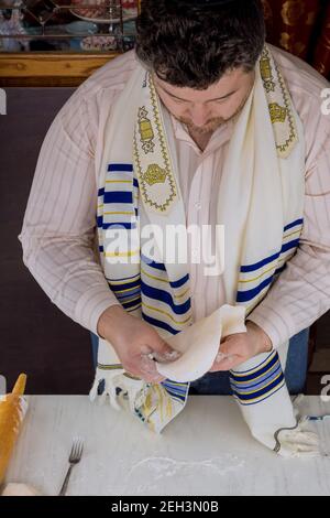 Ebrei ortodossi che arrotola pasta per Matzos per la Pasqua a mettere In forno per la festa ebraica Foto Stock