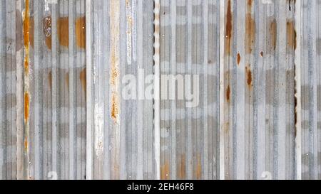 Un pezzo di metallo corrugato arrugginito e resistente agli agenti atmosferici. Lamiera di ferro zincata corrosa. Fondo parete di zinco vecchio Foto Stock