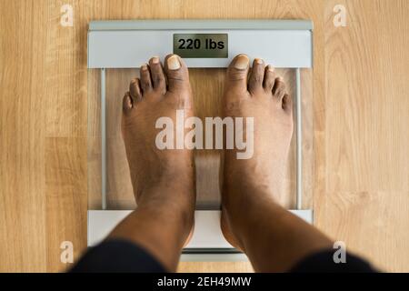 Obesità e perdita di peso. Piedi su scala di peso. Libbre Foto Stock