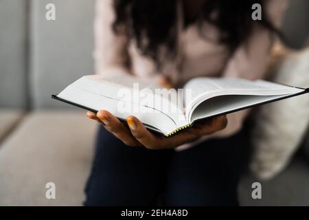 Donna africana di preghiera americana studiando libro della Bibbia nelle mani Foto Stock