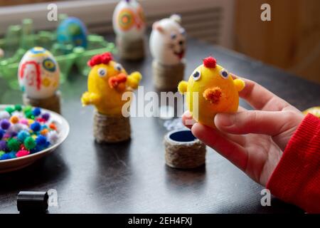 Il bambino ha fatto una figurina di un pollo da un uovo e lo mostra nella cornice, sullo sfondo altre figure Foto Stock