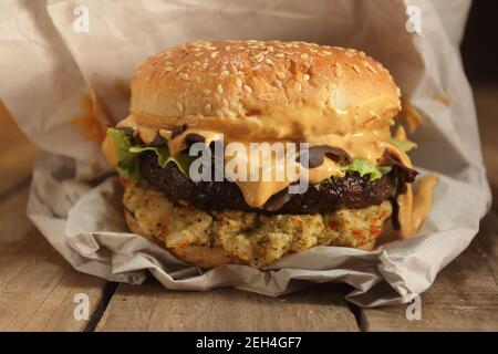 cheeseburger con formaggio fuso avvolto in carta Foto Stock