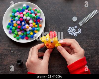 Le mani dei bambini fanno il pollo dalla conchiglia per la vacanza di pasqua, vista dall'alto Foto Stock