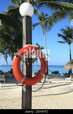 Anello di vita rosso attaccato su un palo sulla spiaggia, Bayahibe, Repubblica Dominicana Foto Stock