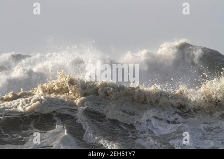 Top una grande ondata di rottura. Mettere a fuoco l'onda in primo piano. Foto Stock