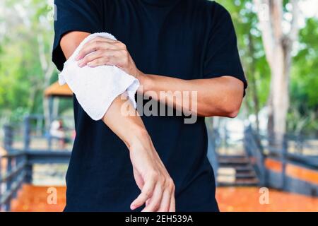Uomo che strofina il sudore nei parchi. Foto Stock