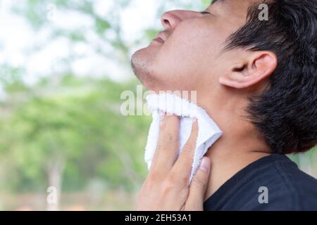 Uomo che strofina il sudore nei parchi. Foto Stock