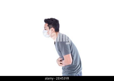 Un uomo malato indossa una maschera igienica e stomachache. Foto Stock