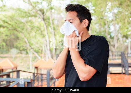 Uomo che strofina il sudore nei parchi. Foto Stock