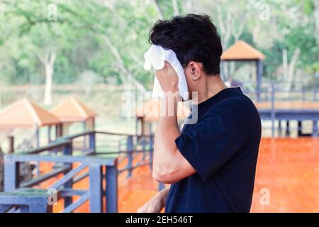 Uomo che strofina il sudore nei parchi. Foto Stock