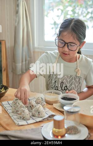 Una ragazza che fa una Onigiri fatta in casa Foto Stock