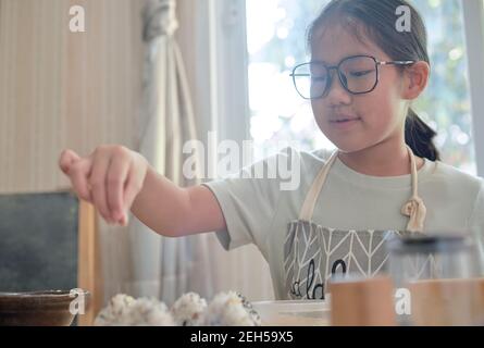 Una ragazza che fa una Onigiri fatta in casa Foto Stock