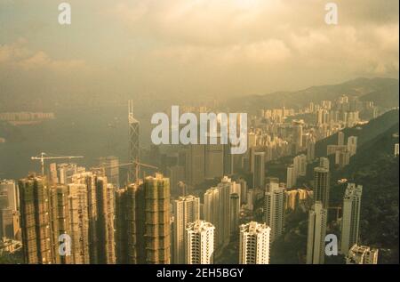 1991 - Isola di Hong Kong e Victoria Harbour da Victoria Peak con la distintiva torre Bank of China costruita nel 1990, l'edificio è notevole per la sua forma e il design distinti, costituito da strutture triangolari coperte da pareti a cortina di vetro. Progettato dall'architetto vincitore del Premio Pritzker I. M. Pei.il profilo dell'edificio da alcuni punti di vista assomiglia a quello di un tagliatore di carne ed è talvolta indicato come "coltello verticale".la costruzione è in corso di molti altri grattacieli alti di Hong Kong, l'isola di Hong Kong Foto Stock