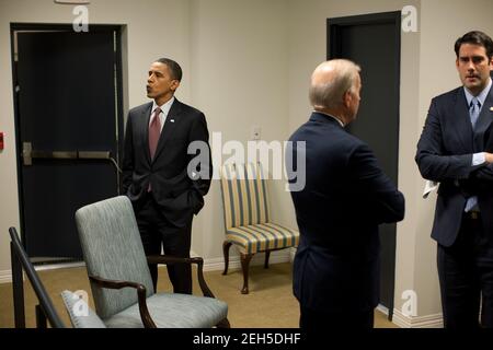 Il presidente Barack Obama fisca mentre lui e il vice presidente Joe Biden attendono nella sala di attesa del South Court Auditorium prima della sessione di apertura del White House Forum sul lavoro e la crescita economica nel Eisenhower Executive Office Building, 3 dicembre 2009. L'assistente personale del Vicepresidente, Fran Person, ha ragione. Foto Stock