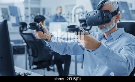 Industrial Design Engineer che indossa il visore per realtà virtuale e i controller di tenuta, utilizza la tecnologia VR per la progettazione industriale e lo sviluppo Foto Stock