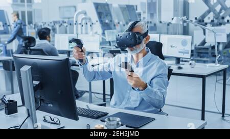 Industrial Design Engineer che indossa il visore per realtà virtuale e i controller di tenuta, utilizza la tecnologia VR per la progettazione industriale e lo sviluppo Foto Stock