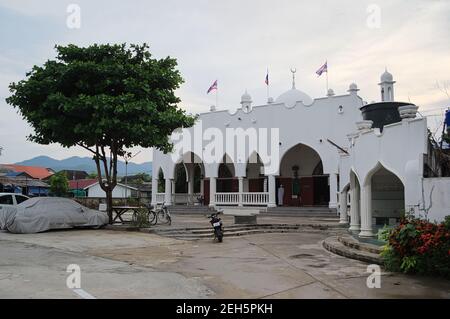 PAI, Thiland - Giugno, 2015: Edificio bianco moschea della città al tramonto. Bandiere nazionali thailandesi sul tetto. Foto Stock