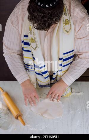 L'uomo ebreo ortodosso prepara a mano kosher piatto matzah per cottura Foto Stock