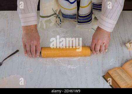 L'uomo ebreo ortodosso prepara a mano kosher piatto matzah per cottura Foto Stock