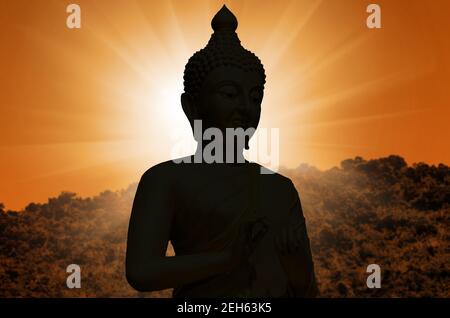 Magha Asanha Visakha Puja giorno. Silhouette Buddha su sfondo tramonto sfocato. Foto Stock