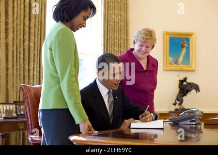 Christina Romer, presidente del Consiglio dei consiglieri economici, e Cecilia Rouse, membro del Consiglio dei consiglieri economici, osservano la firma da parte del presidente Barack Obama del rapporto economico del presidente dell'Ufficio ovale, 11 febbraio 2010. Foto Stock