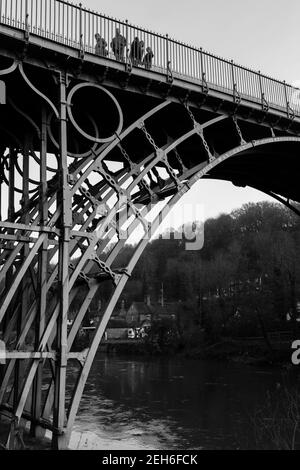 TELFORD, Regno Unito - 18 febbraio 2013. Un gruppo di turisti attraversa il ponte di ferro, il primo ponte ad arco in ghisa costruito sopra la gola di Ironbridge all'inizio Foto Stock