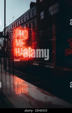 Londra UK Gennaio 2021 Pho me Hard neon segno nel centro di Londra, che fa pubblicità a un ristorante cinese noodle lo mein. Rosso luminoso a notte dur Foto Stock