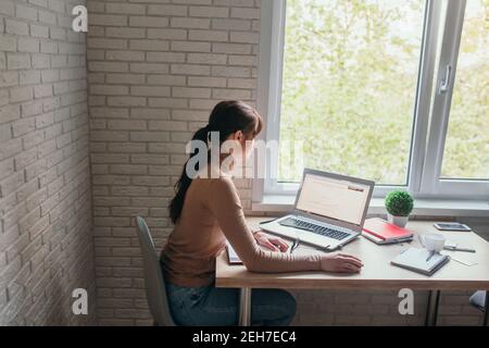 Sorridente e bellissimo freelance che lavora a distanza da casa. Foto Stock