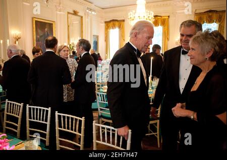 Il Vice Presidente Joe Biden parla con il Segretario ai Trasporti Ray LaHood e con sua moglie, Kathy LaHood, prima della cena di Stato nella Sala Est della Casa Bianca, 19 maggio 2010. A sinistra, il Segretario di Stato Hillary Rodham Clinton e il Segretario per l'energia Steven Chu parlano con altri ospiti. Foto Stock