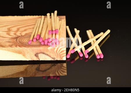 Diversi incontri di legno giacciono su una tavola di legno su uno sfondo nero. Foto Stock