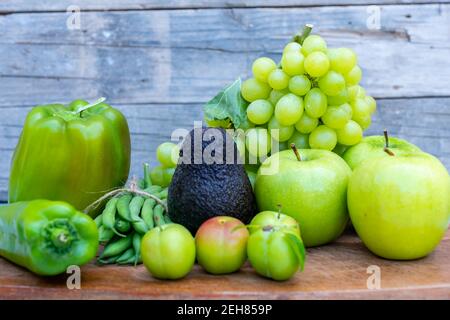 Verdure verdi e frutta su un tagliere Foto Stock
