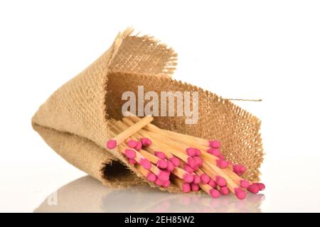 Diversi fiammiferi di legno giacciono su tessuto di iuta, su uno sfondo bianco. Foto Stock