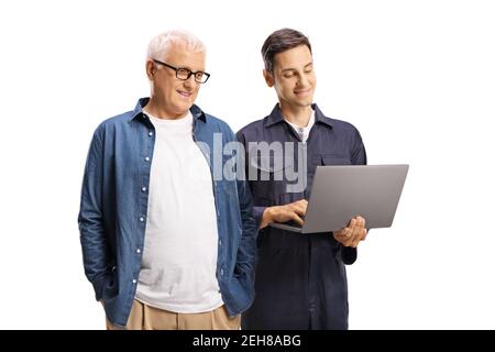 Uomo maturo e un giovane meccanico lavoratore che guarda un computer portatile isolato su sfondo bianco Foto Stock