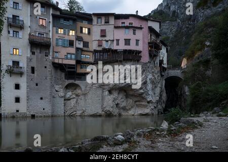 Vista lungo il fiume di una delle caratteristiche abitazioni sospese di Pont-en-Royans, nella regione Auvergne-Rodano-Alpi, durante il crepuscolo. Foto Stock