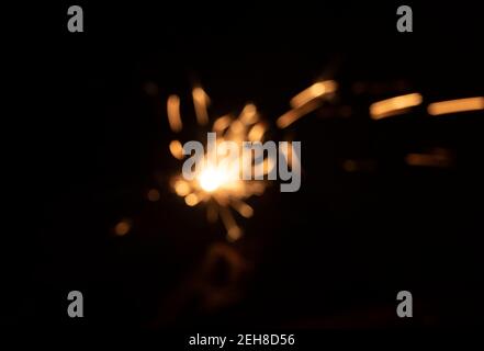Scintille deboli dal fuoco davanti al nero sfondo Foto Stock
