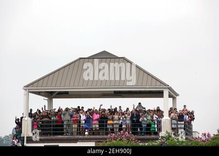 Le persone su una piattaforma di osservazione guardano e ondano mentre il presidente Barack Obama arriva alla base della Riserva aerea di Dobbins a Marietta, GA., 2 agosto 2010. Il presidente si trovava ad Atlanta per parlare all'VIII Convegno Nazionale dei Veterani Americani disabili. Foto Stock