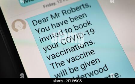 NHS SMARTPHONE VACCINATION INVITA MESSAGGIO RE COVID -19 VIRUS DEL CORONAVIRUS VACCINO PANDEMICO ROAD MAP ROLLOUT JAB ECC UK Foto Stock