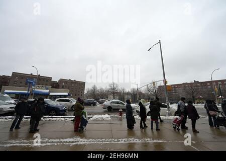 New York, Stati Uniti. 19 Feb 2021. La gente si trova in fila fuori dall'Elmhurst Hospital in Queens per aiutare a ricevere cibo durante la Lunar New Year Celebration distribuzione di cibo per i residenti della comunità nel quartiere Queens di New York City, NY, 19 febbraio 2021. Poiché l'impatto della pandemia COVID-19 continua a colpire l'economia, si stima che l'insicurezza alimentare negli Stati Uniti sia raddoppiata e triplicata nelle famiglie con bambini. (Foto di Anthony Behar/Sipa USA) Credit: Sipa USA/Alamy Live News Foto Stock