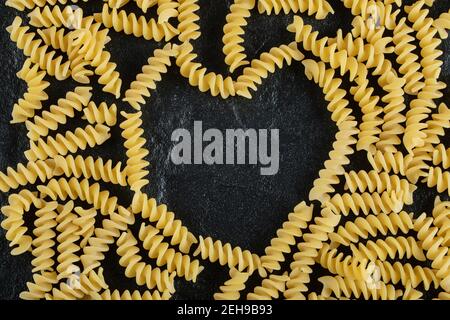 Mazzo di fusilli non cotti su sfondo scuro Foto Stock