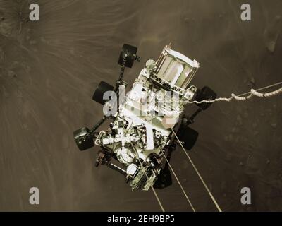 Questa immagine fissa ad alta risoluzione fa parte di un video preso da diverse telecamere, come la perseveranza rover della NASA ha toccato su Marte il 18 febbraio 2021. Questa foto è stata scattata da una fotocamera a bordo del palcoscenico in discesa. Un obiettivo chiave per la missione di perseveranza su Marte è l'astrobiologia, compresa la ricerca di segni di antica vita microbica. la rover caratterizzerà la geologia del pianeta e il clima passato, spianerà la strada all'esplorazione umana del pianeta Rosso, e sarà la prima missione di raccogliere e conservare la roccia marziana e il regolito (roccia e polvere spezzate). Successive missioni della NASA, in collaborazione con l'ESA (l'EUR Foto Stock