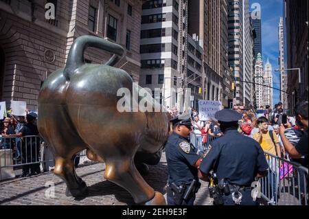 New York, Stati Uniti. 20 settembre 2019. Gli agenti di polizia proteggono la statua del toro di Wall Street a Broadway durante lo sciopero del clima giovanile. Foto Stock
