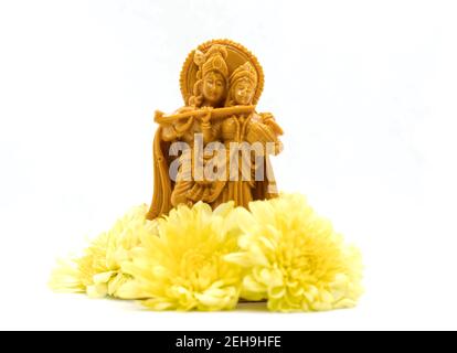 La statua di Radha Krishna con fiori è isolata uno sfondo bianco Foto Stock