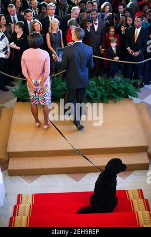 Il presidente Barack Obama è Unito da First Lady Michelle Obama e Bo, il cane della famiglia Obama, come egli rende le osservazioni durante un ricevimento di Natale nel Grand Foyer della Casa Bianca, 15 dicembre 2010. Foto Stock