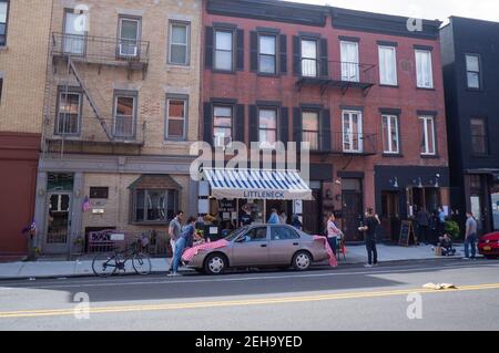 Brooklyn, NY, Stati Uniti. 31 maggio 2020. I commensali usano un'auto parcheggiata sulla strada come un tavolo di fortuna per cenare all'aperto durante la pandemia di Coronavirus a New York. Foto Stock