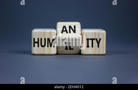 Simbolo dell'umiltà contro l'umanità. Voltò i cubetti e cambiò la parola 'umiltà' in 'umanità'. Bel tavolo grigio, sfondo grigio, spazio copia. Azienda A. Foto Stock