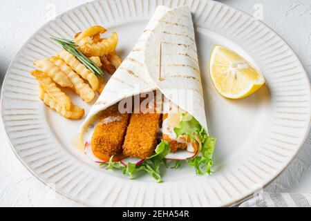 Panino con dita di pesce, formaggio e verdure, su piatto, su fondo bianco Foto Stock