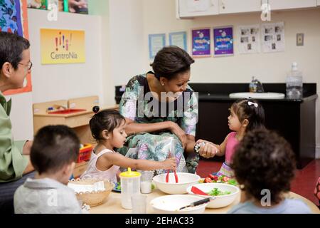 La First Lady Michelle Obama parla con i bambini mentre pranzano al Centro di assistenza all'infanzia CentroNía di Washington, D.C., 8 giugno 2011. Foto Stock